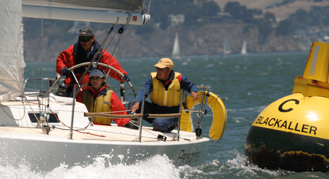 Three people sailing in choppy water