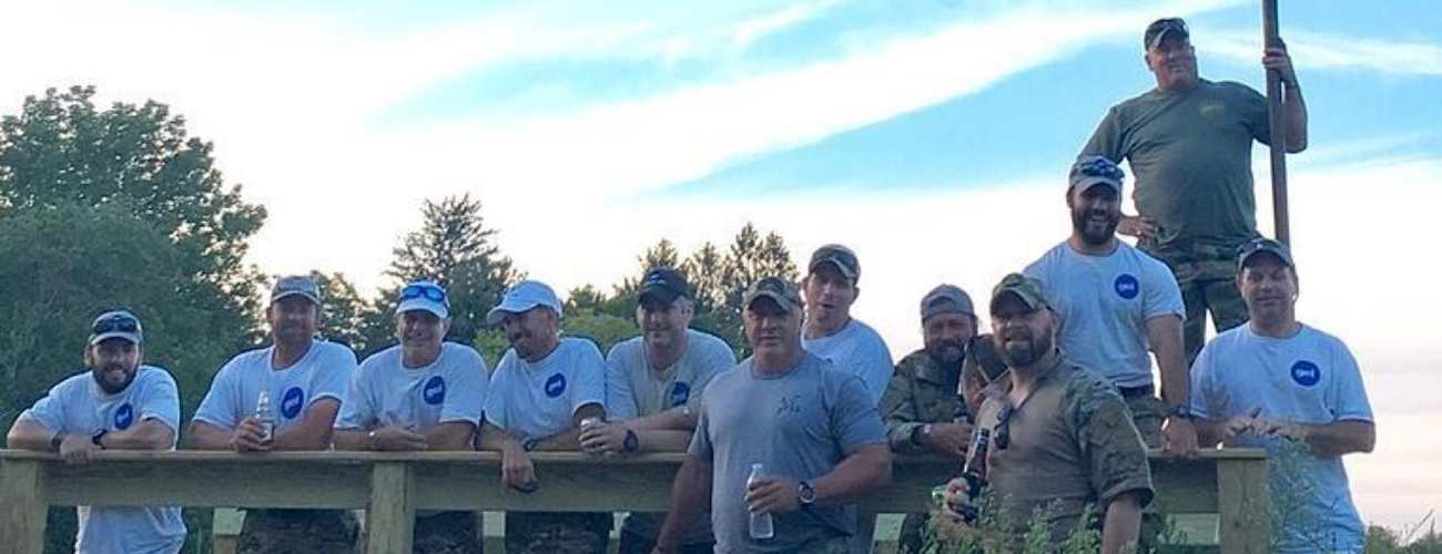 Team members standing together behind a fence